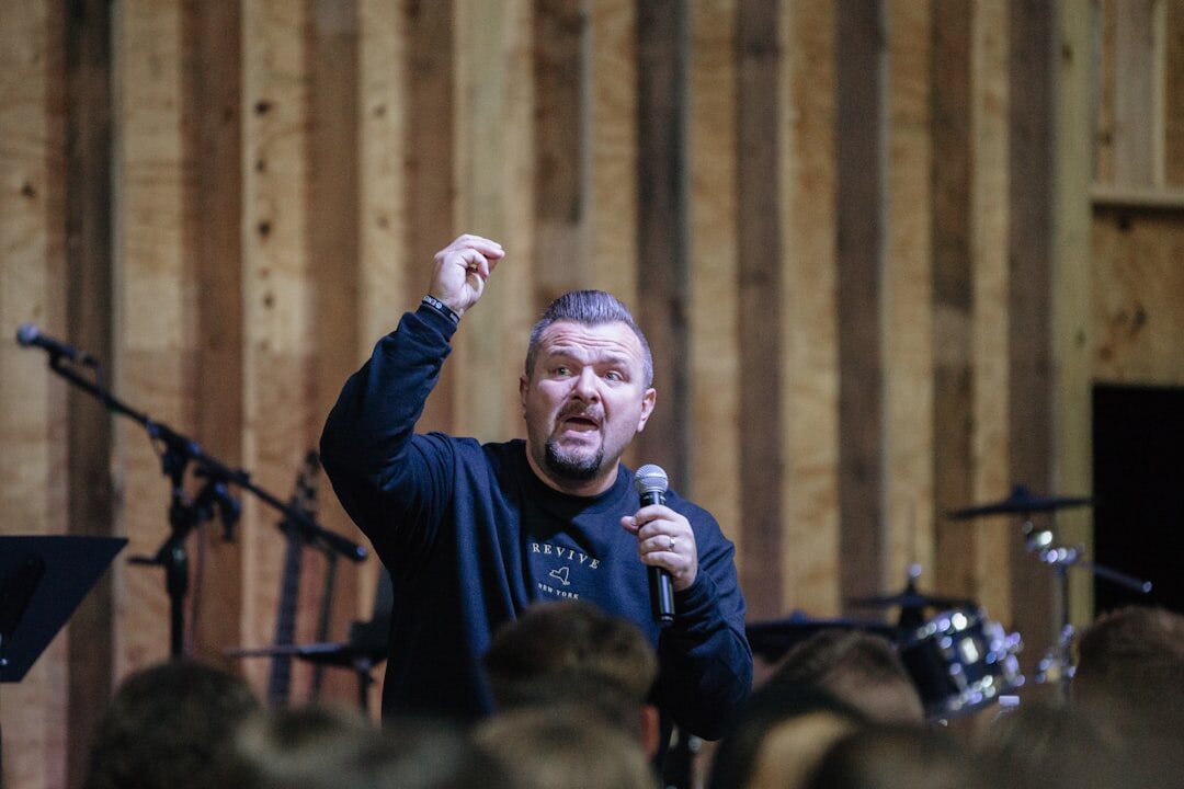 Moderator standing in front of an audience holding a microphone