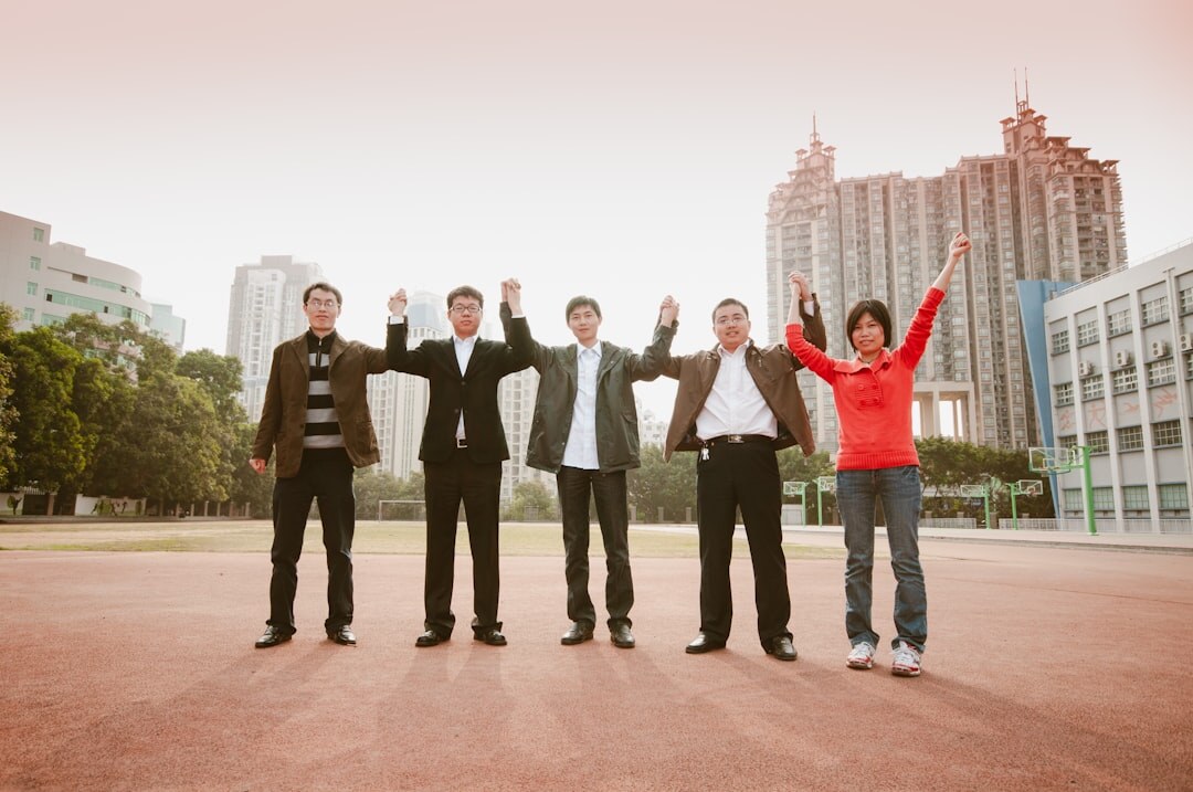 Team of young professionals celebrating success together outdoors